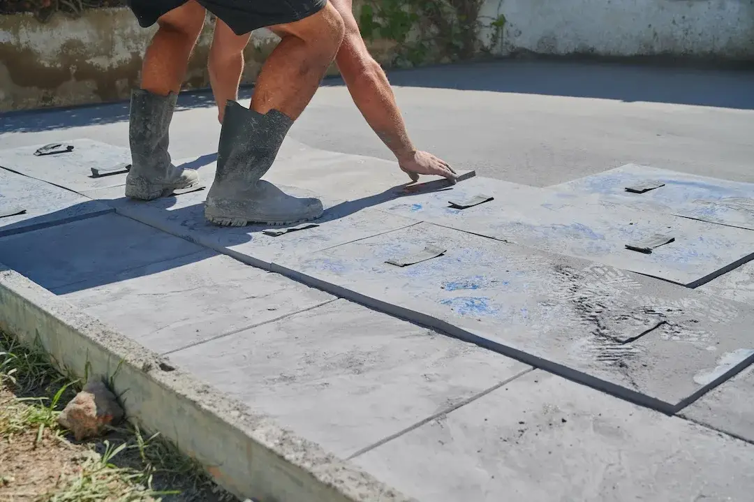 Texturing fresh concrete with a decorative stamping mat